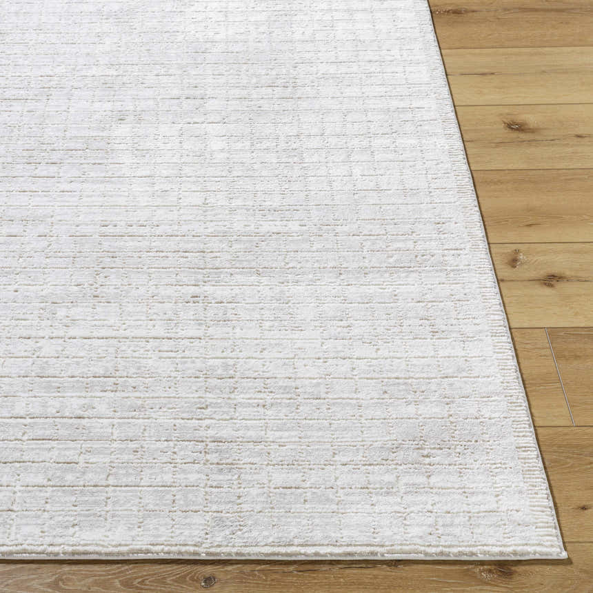 Close-up of the cream Arnulf 3D Textured Washable Rug showing its subtle pattern and soft texture on wood floor. Front