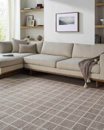 Living room with a beige sectional sofa and the Anicet Checkered Washable Wool Area Rug in beige and cream. Roomscene-Rectangle