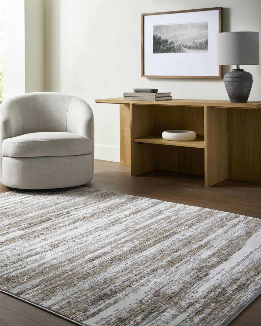 Living room scene with a gray swivel chair and the Aminia Area Rug in shades of white, gray, and brown. Roomscene-Rectangle