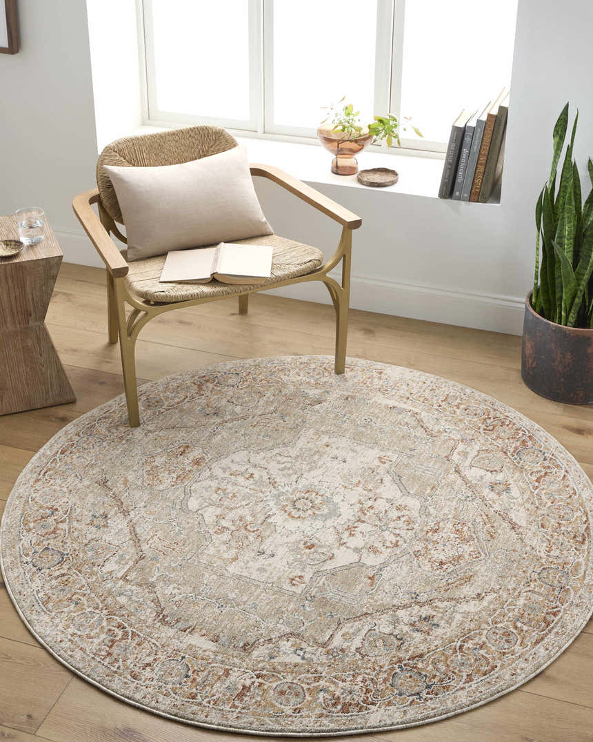 Cozy reading nook with round Armoni Area Rug in beige, cream, and blue under a woven chair and wood side table. Roomscene-Round