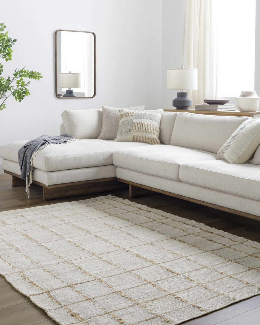 Living room with a cream sectional sofa and the Zared Checkered Jute Area Rug in ash, light silver, and sage. Roomscene-Rectangle