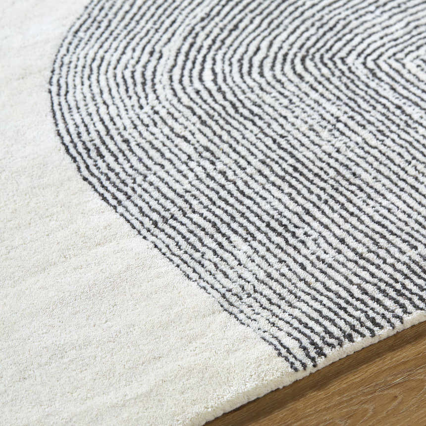 Close-up of the hand-tufted Zytka Area Rug. Desert Sand and Silver Gray wool with a contemporary striped, curved design. Texture