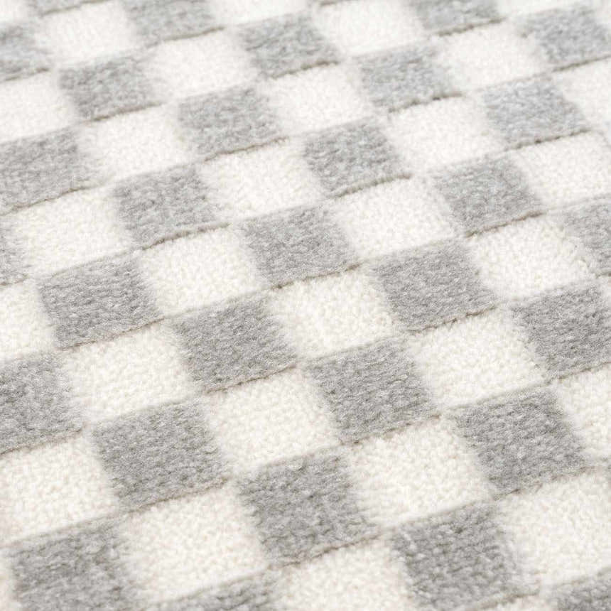 Close-up of Gaiwan Cream Gray Washable Area Rug showing checkerboard pattern and soft, textured weave. Texture