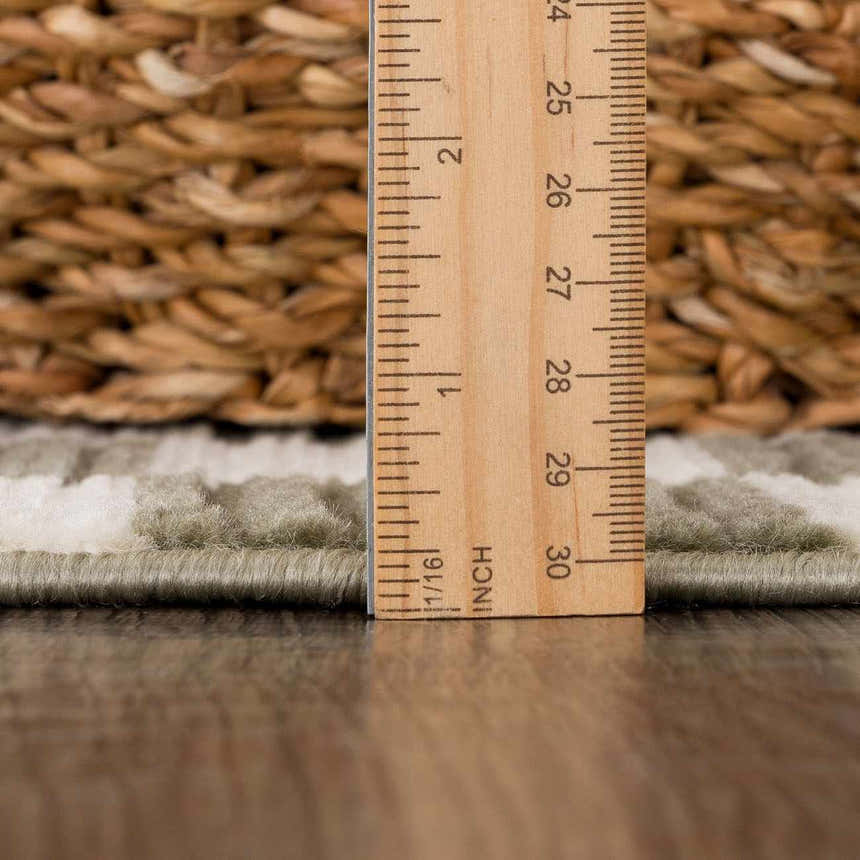 Close up of the Kaysar Olive Green Checkered Washable Area Rug pile height with ruler and basket. Pile