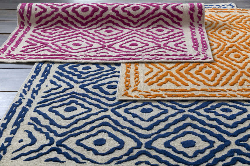 Close-up of Westhill Area Carpet in fuchsia, peach, and blue. Hand-knotted wool rug with diamond pattern. Farmhouse style. Styleshot
