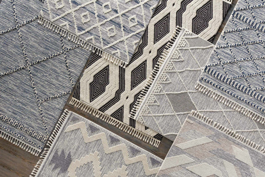 Close-up of Norvelt High/Low Pile Rugs with Tassels. Bohemian style rugs in black, gray, and ivory with geometric patterns. Styleshot