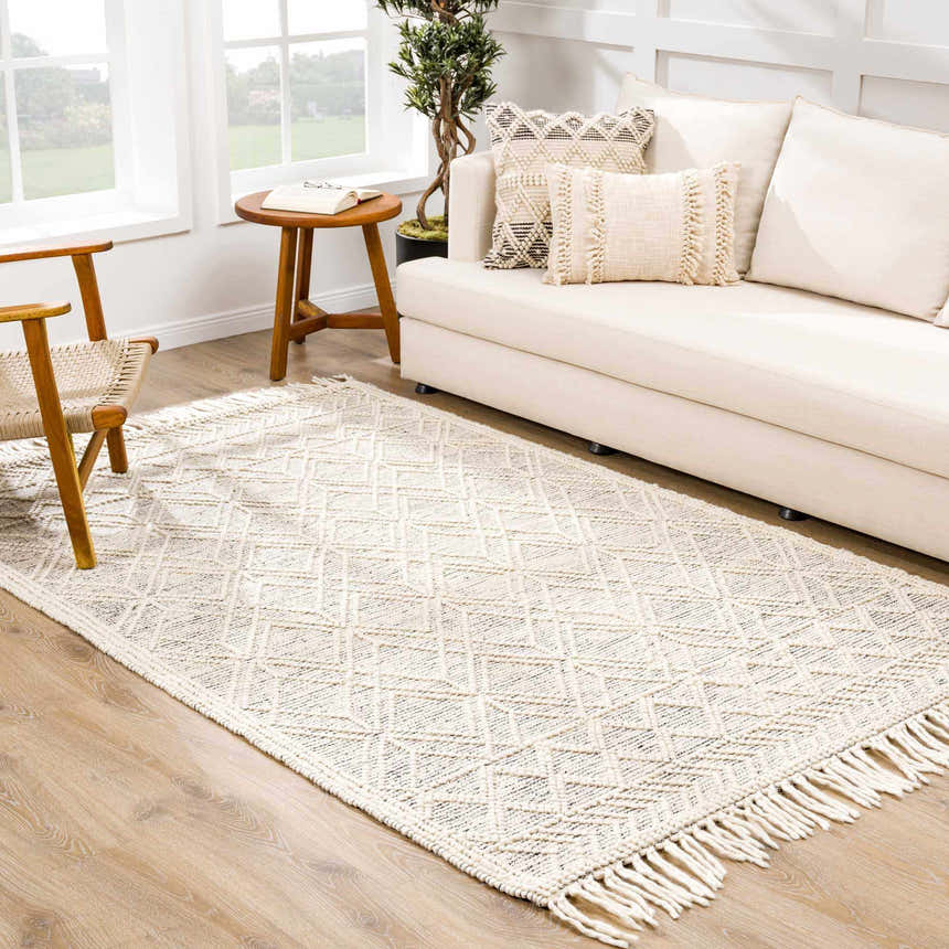 Living room scene with ivory sofa and Ramsbury Wool Area Rug with geometric pattern and fringe. Roomscene-Rectangle
