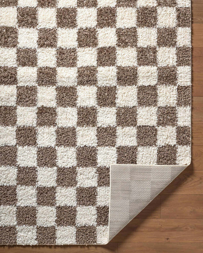 Close up of the Neftekamsk Area Rug. Brown and white checkerboard pattern, shaggy texture. Fold