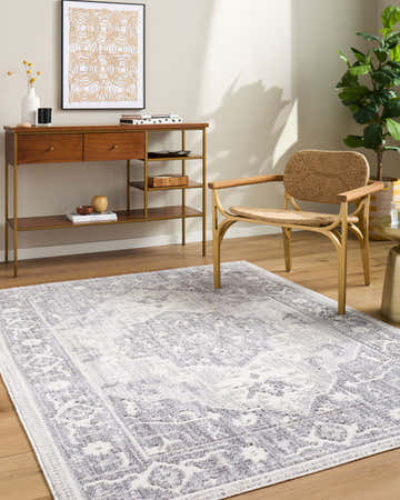 Living room scene with Odeon Elle Decor x LIVABLISS rug in charcoal, cream, and gray. Console table, woven chair, and plant. Roomscene-Rectangle
