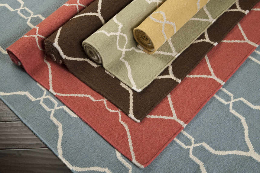 Rolled Partington Brown Wool Carpet Area Rugs in brown, peach, blue, and green with a geometric pattern. Styleshot