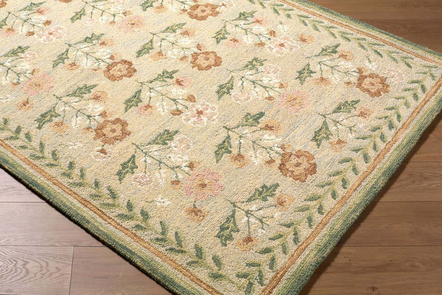 Close-up of the hand-tufted Acacia Area Rug. Beige wool rug with a floral pattern in pink, white, brown, and green. Corner