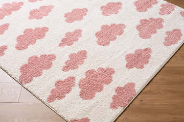 Close-up of Gonu Ivory Abstract rug. Pink abstract shapes on a textured, machine-woven polyester rug. Corner
