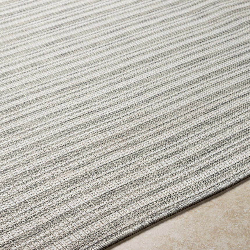 Close-up of the Greg Area Rug in lambswool and smoke, showing the woven texture and subtle striped pattern. Texture