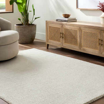 Living room scene with a light beige swivel chair and Sezja White Luxe Area Rug. Roomscene-Rectangle