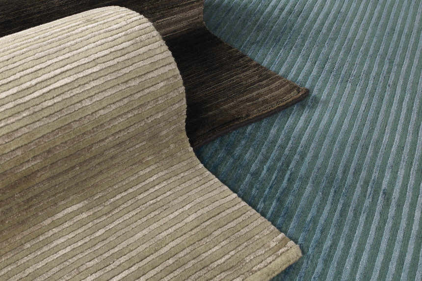 Close-up of the striped Sanatoga Area Rug in beige, brown, and blue. Hand-knotted wool and viscose rug texture. Styleshot