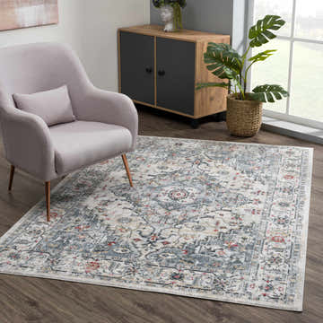 Living room scene with a gray chair and the cream and gray Billings Area Rug. Roomscene-Rectangle