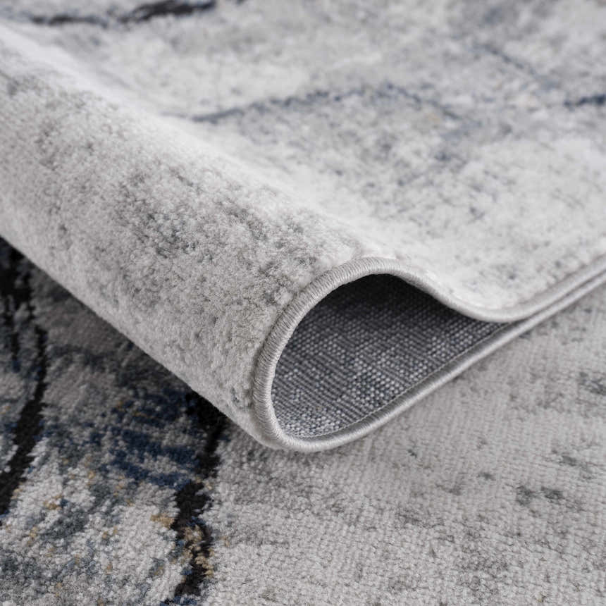 Close-up of the Fremantle Gray Marble Rug showing its cream, gray, and gold contemporary pattern and machine-woven texture. Fold