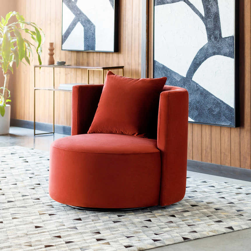 Living room scene with a Horasan Area Carpet in black, gray, and tan under a modern orange chair. Abstract art on the wood-paneled wall. Styleshot