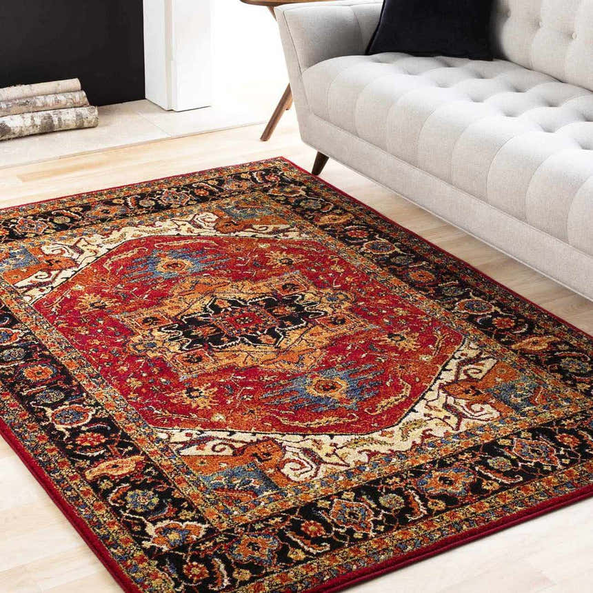 Living room scene with a red, black, and orange Oriental style Malpas Area Rug under a light gray sofa. Roomscene-Rectangle
