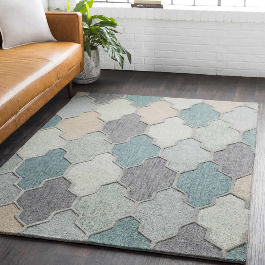 Living room scene with a Monteview Sage&Teal Geometric Wool Rug, leather couch, and white brick wall. Farmhouse style. Roomscene-Rectangle