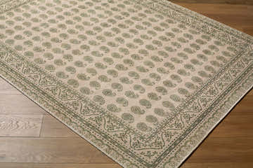 Close-up of Alo Machine Woven Nabela Noor Home x LIVABLISS rug. Green paisley pattern on off-white jute blend. Farmhouse style. Corner