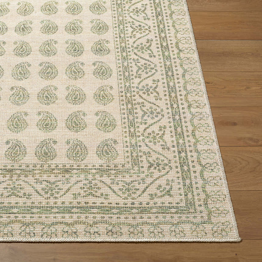 Close-up of Alo Nabela Noor Home x LIVABLISS NBAL-2302 Area Rug. Green paisley pattern on off-white jute blend, on wood floor. Front