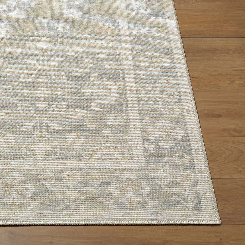 Close-up of Asha Machine Woven Nabela Noor Home rug. Farmhouse style rug in mustard, off-white, and sage on wood floor. Front