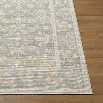 Close-up of Asha Machine Woven Nabela Noor Home rug. Farmhouse style rug in mustard, off-white, and sage on wood floor. Front