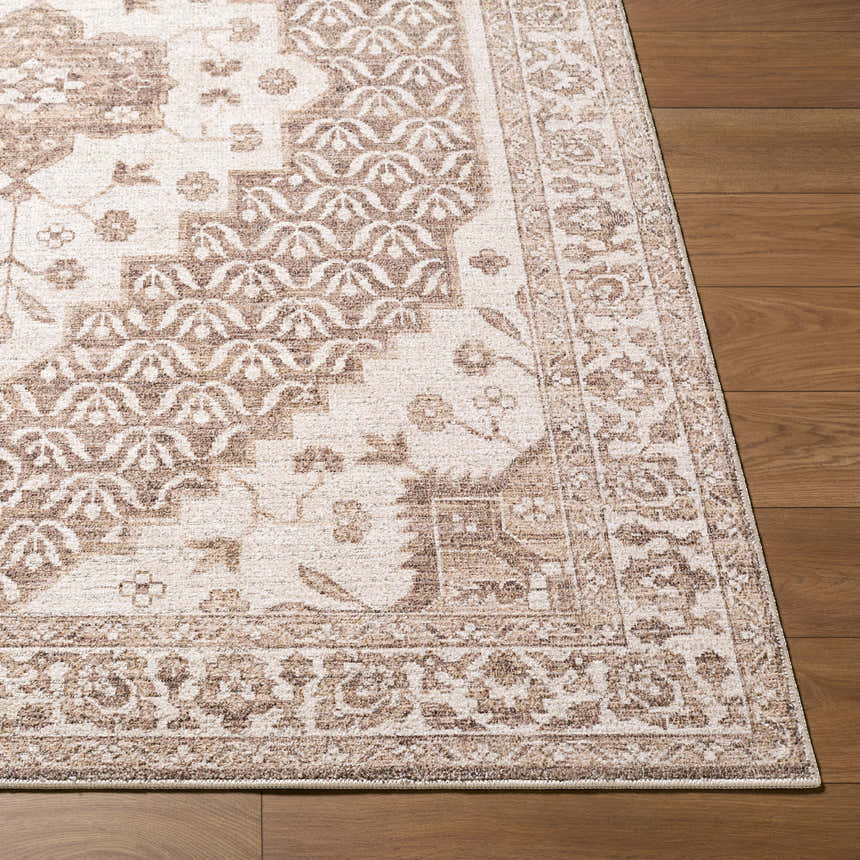 Close-up of the Athiyo Nabela Noor Home x LIVABLISS NBAT-2305 area rug with a traditional brown and gray pattern on wood floors. Front