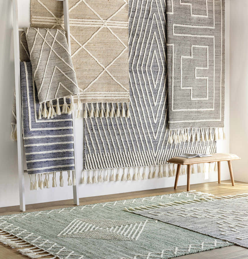 Room scene with a ladder displaying jute and wool rugs with tassels, plus a light brown bench. Marbletown rug is featured. Styleshot