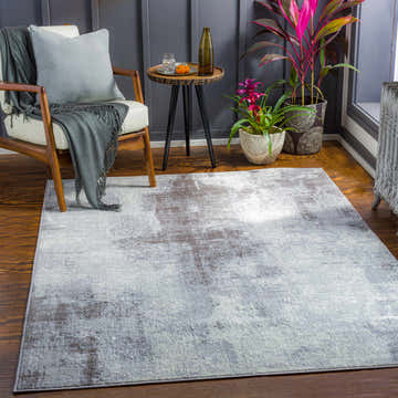Living room scene with a cream chair and gray Paulba Area Rug. Roomscene-Rectangle