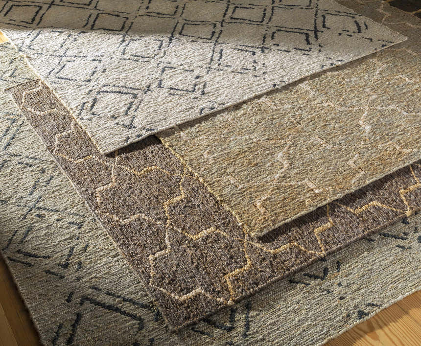 Close-up of textured Oltu Jute Carpet in beige and black, featuring a geometric pattern and hand-woven construction. Styleshot