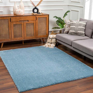 Living room scene with a Heavenly Solid Blue Plush Rug, gray sofa, and wood cabinet. Roomscene-Rectangle