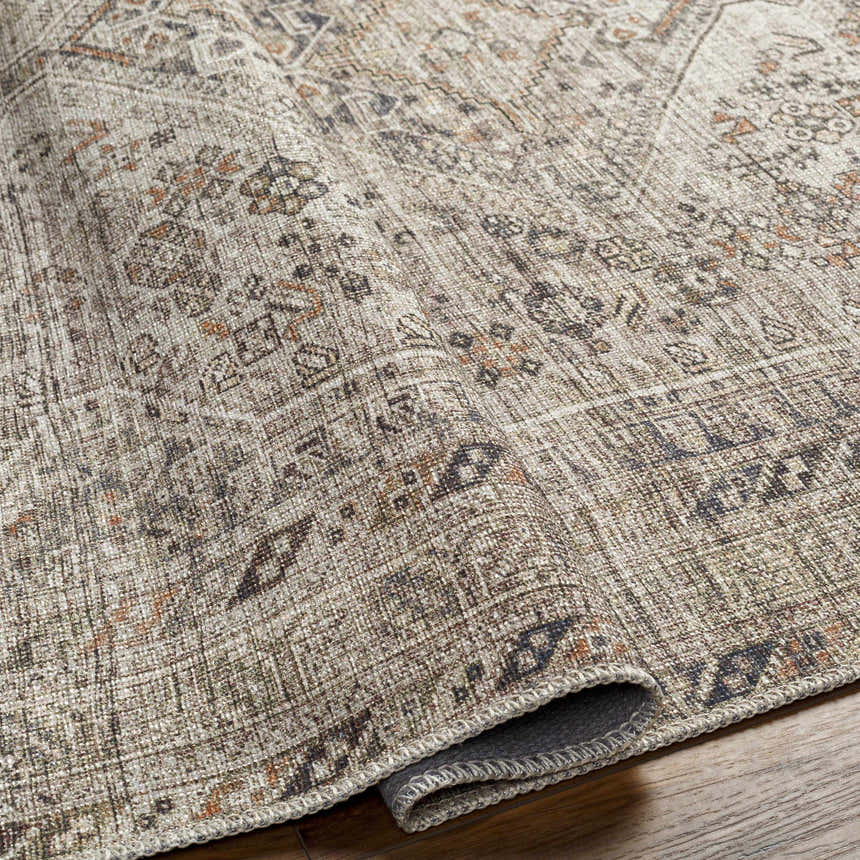 Close-up of the Barny Beige Flat Pile Washable Rug showing its traditional pattern, neutral colors, and flatweave texture. Fold