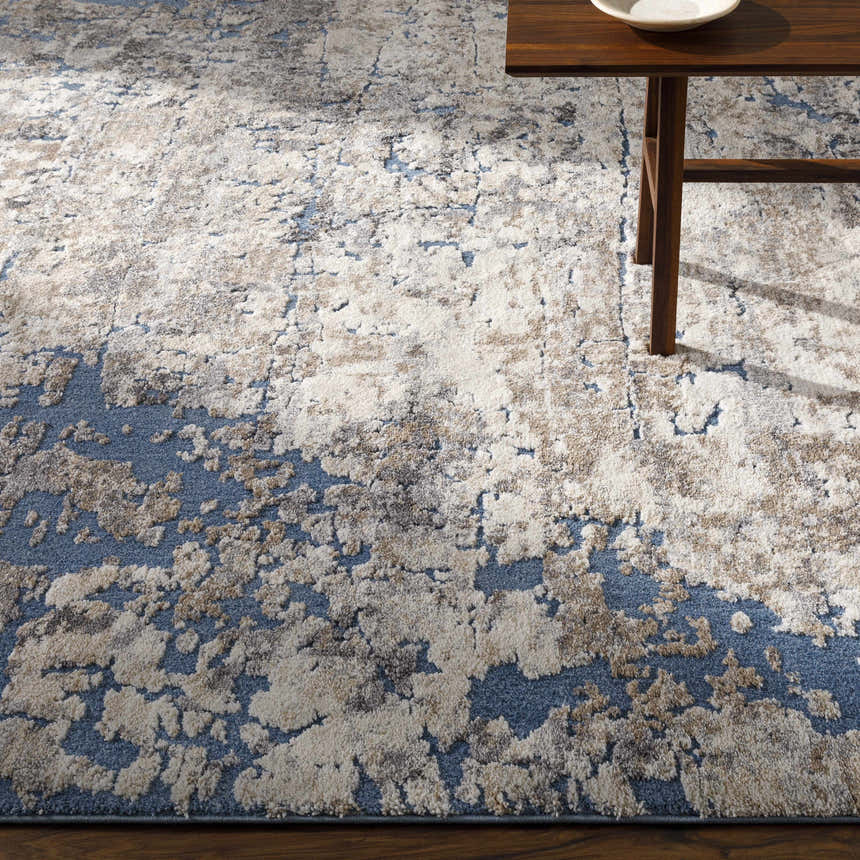 Close-up of Satsop Rock Pattern Thick Rug in a living room with a wood side table and a neutral rock pattern. Styleshot