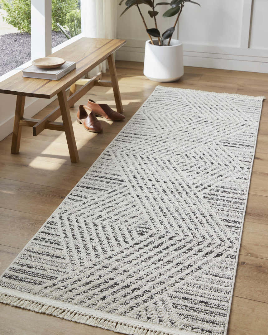 Entryway with Brita Area Rug runner in bone and cloud gray, wood bench, and brown leather shoes. Roomscene-Runner