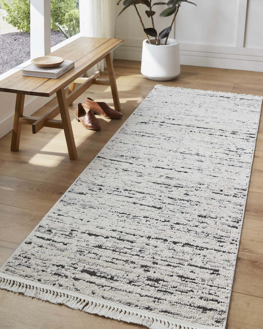 Hallway scene with Elian Area Rug in bone and gray, wood bench, and potted plant. Roomscene-Runner