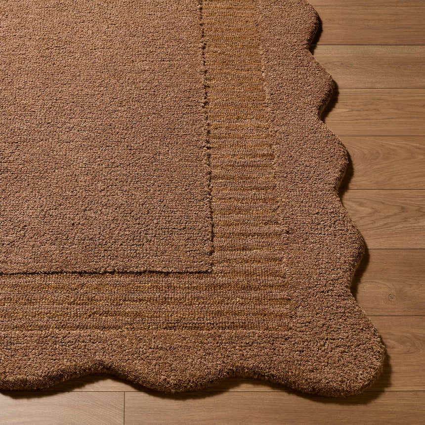 Close-up of the textured Gurib Border Modern wool rug in tan, showing the hand-tufted construction and scalloped edge. Front