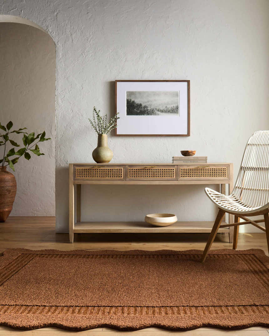 Entryway with a Gurib Border Modern wool rug, console table, textured walls, and a white chair. Roomscene-Rectangle