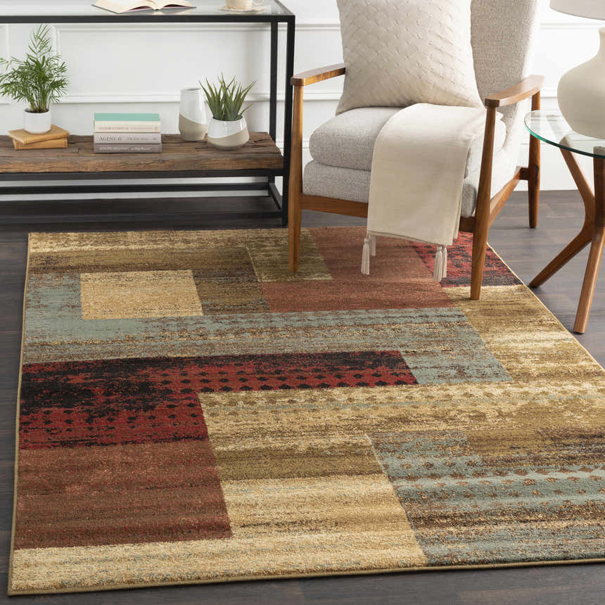 Living room scene with a Sentinel Riley Geometric Rug in red, brown, black, and green tones. Modern armchair and side tables. Roomscene-Rectangle