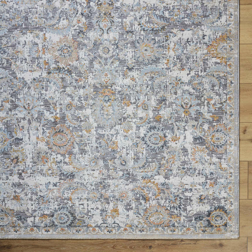 Close-up of the Atara Area Rug featuring a traditional gray, brown, and blue distressed floral pattern. Corner