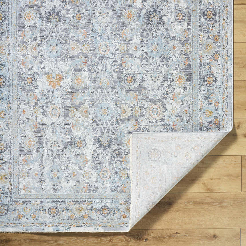 Close-up of the Finn Silver Blue Area Rug showing its traditional floral pattern and silver, gray, and blue colors. Fold