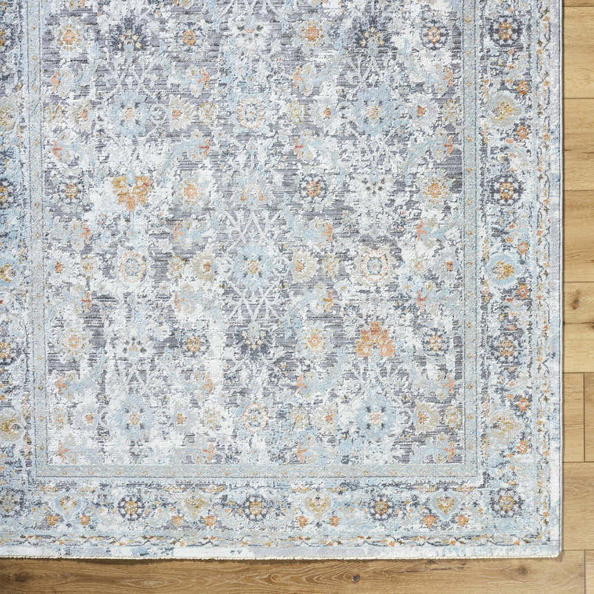 Close-up of the Finn Silver Blue Area Rug showing its traditional floral pattern and silver, gray, and blue tones. Corner
