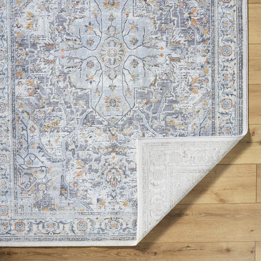 Close-up of the Hewez Area Rug in cloud gray, dark gray, and nutmeg on a wood floor, showing its traditional, distressed pattern. Fold