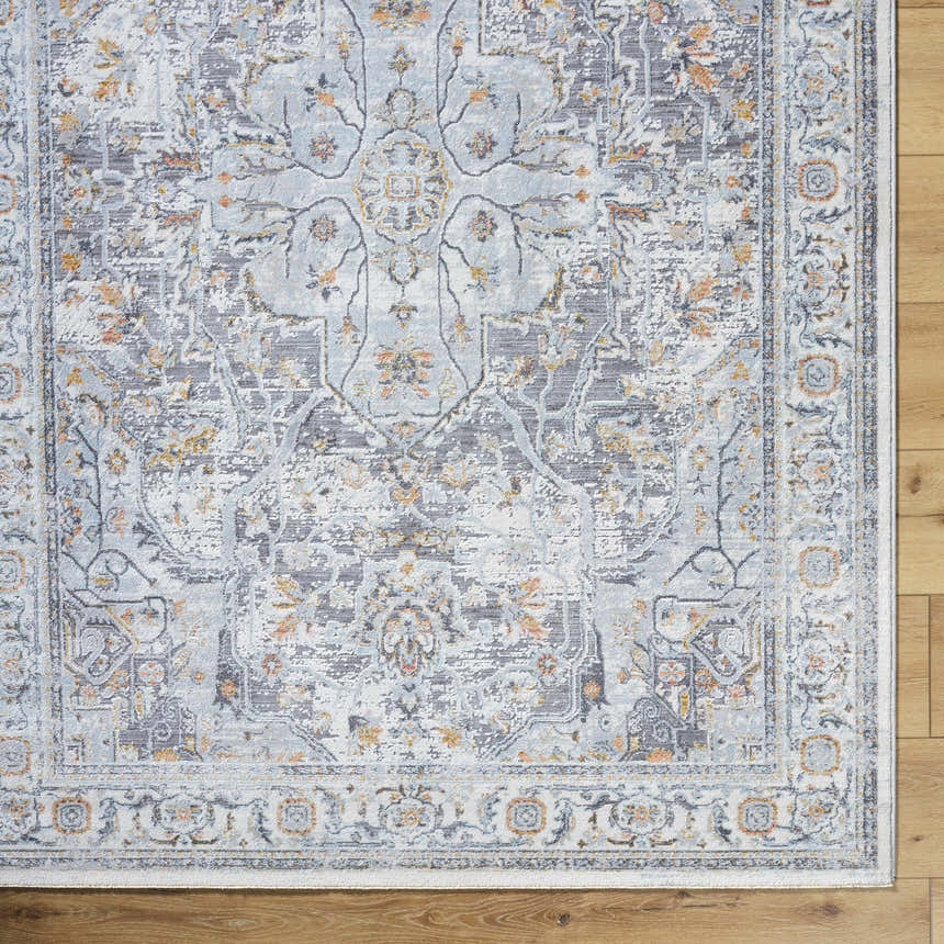 Close-up of Hewez Area Rug with traditional gray, nutmeg, and light blue floral pattern on a wood floor. Corner
