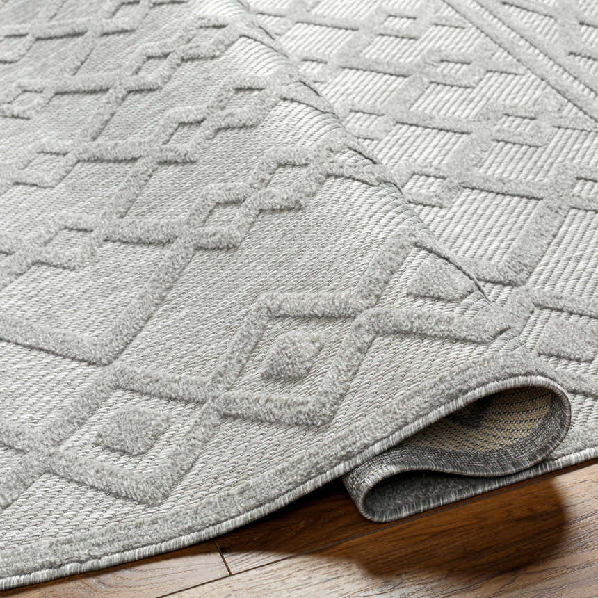 Close-up of the Kort SFG-2310 area rug, a machine woven rug in bone, natural gray, and taupe with a geometric design. Fold
