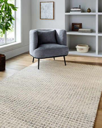 Entryway with gray chair and Anahid Beige area rug. Checkered wool rug in light silver, off-white, and slate blue colors. Roomscene-Rectangle