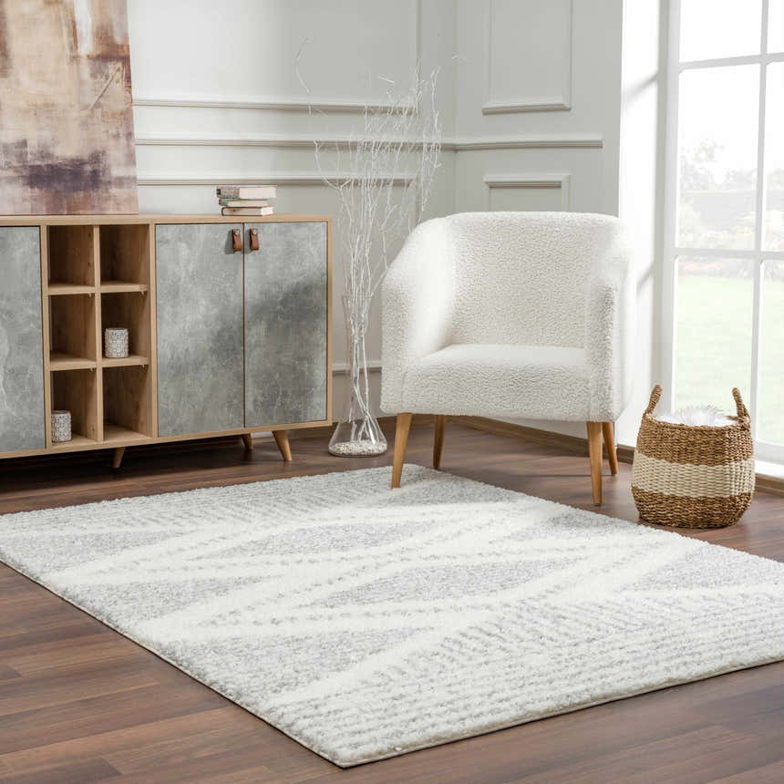 Living room scene with Trunding Plush Area Rug in Gray, white sherpa chair, and modern cabinet. Roomscene-Rectangle