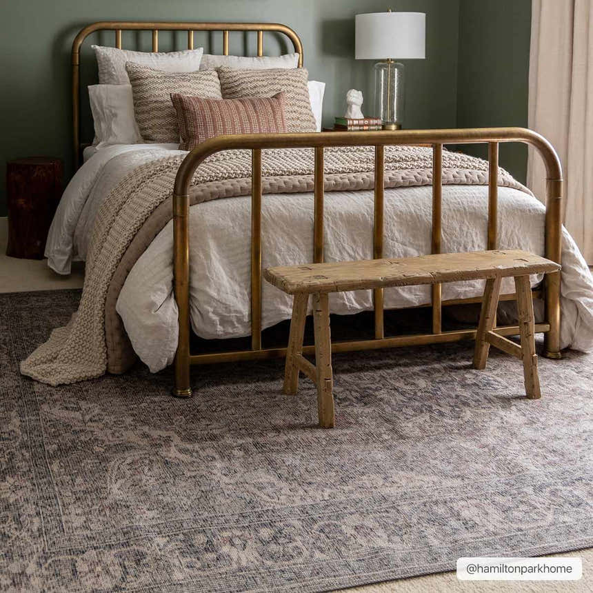 Bedroom scene with gold bed frame and Greenpoint Dusty Blue Washable Rug. Vintage style with beige and blue tones. Roomscene-Rectangle