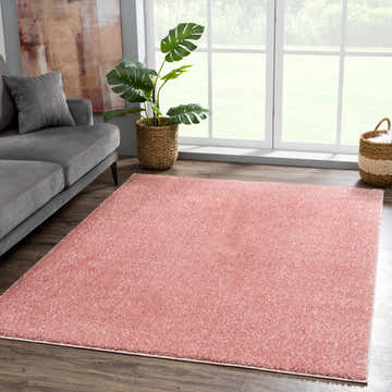 Living room scene with gray sofa and Judy Pink Plush Washable Area Rug adding soft color to the space. Roomscene-Rectangle